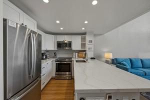 a kitchen with a stainless steel refrigerator and a blue couch at Prime Oceanfront 2BR Loft - Unit C10 condo in Lahaina