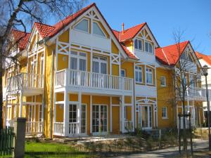 ein gelbes und weißes Haus mit orangefarbenem Dach in der Unterkunft Uns Strandhus in Kühlungsborn