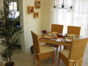 a dining room with a table and chairs and a plant at Uns Strandhus in Kühlungsborn