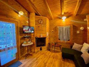 a living room with a couch and a tv at Casa vacanza Chalet Baita nel Bosco in LʼAquila