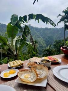 a table topped with eggs and bread on top of a table at Ella Antara Green Wood Cottage in Ella