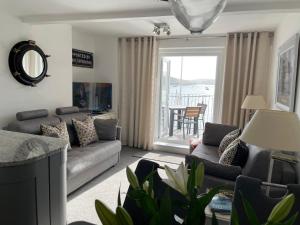 a living room with a couch and a table at 35 The Salcombe in Salcombe