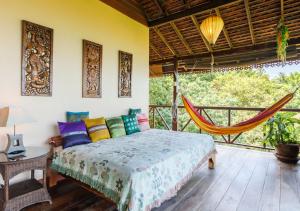 a bedroom with a bed and a hammock at Villa Anahata in Ban Tai