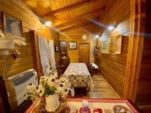 a room with a bed and a table with flowers at Casa vacanza Chalet Baita nel Bosco in LʼAquila