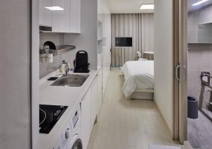 a kitchen with a sink and a bed in a room at Incheon Songdo Stay31 in Incheon