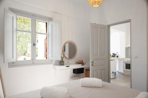 a white bedroom with a bed and a mirror at Limonletto in Patmos