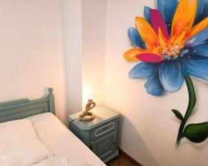 a bedroom with a painting of a flower on the wall at Ferienwohnung Feenblick in Kurort Altenberg