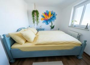 a bed in a room with a flower on the wall at Ferienwohnung Feenblick in Kurort Altenberg