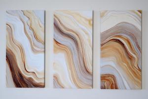 three pieces of art on a white wall at Sable Shores in Batemans Bay