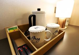 a tray with two coffee cups on a desk at Gangneung Grey Hotel in Gangneung