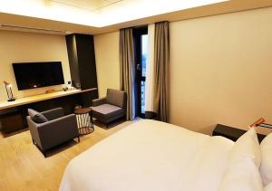 a hotel room with a large bed and a television at Gangneung Grey Hotel in Gangneung