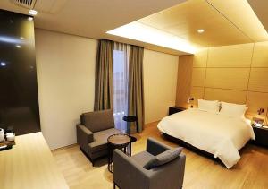 a hotel room with a bed and a chair at Gangneung Grey Hotel in Gangneung +14 photos