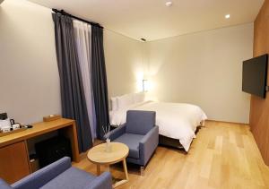 a hotel room with a bed and a couch at Gangneung Grey Hotel in Gangneung