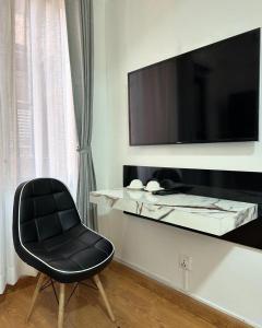 a black chair sitting next to a table with a television at Ivanna stay in Pātan +7 photos