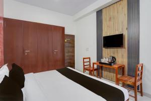 a bedroom with a bed and a desk and a tv at Townhouse Manipal University Highway King Bagru Formerly Golden Hotel in Jaipur +21 photos