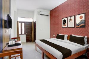 a bedroom with a large bed and a red wall at Townhouse Manipal University Highway King Bagru Formerly Golden Hotel in Jaipur
