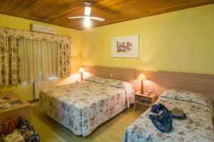 a hotel room with two beds and a ceiling at Hotel Sky Gramado in Gramado