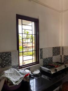 a kitchen with a window and a counter top at Green Stay,AC room in Sibsāgar