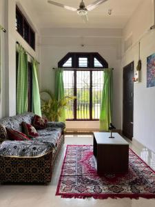 a living room with a couch and a table at Green Stay,AC room in Sibsāgar