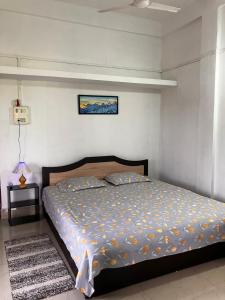 a bedroom with a bed in a white room at Green Stay,AC room in Sibsāgar