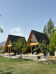 a wooden house with a black roof at A-Frame House Tosor in Tossor