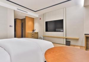 a bedroom with a bed and a table and a tv at 대구 빌리언웨스턴호텔 in Daegu