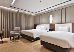 a hotel room with two beds and a desk and chair at 대구 빌리언웨스턴호텔 in Daegu +54 photos