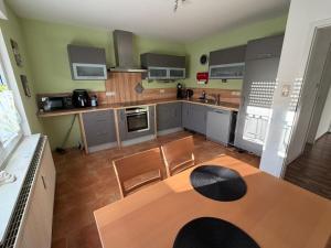 a large kitchen with a table and chairs in it at Ferienwohnung Alina in Hilders