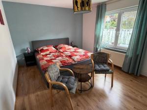a bedroom with a bed and two chairs and a table at Ferienwohnung Alina in Hilders