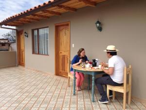 een man en vrouw aan een tafel op de patio bij San Rocke House in Cuenca