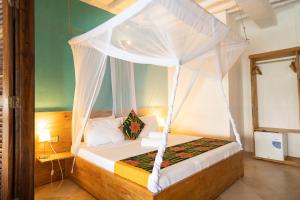 a bedroom with a bed with a canopy at ZAN Jambiani Beach House in Jambiani