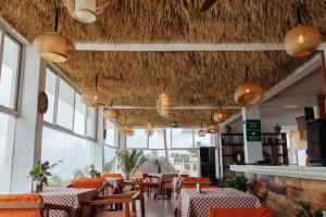 a dining room with tables and chairs and windows at ZAN Jambiani Beach House in Jambiani