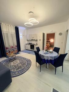 a living room with a table and chairs and a kitchen at Stefy's House in Scalea