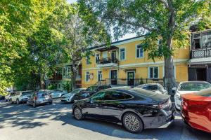 a row of cars parked in front of a yellow building at Aureline Hill in Baku