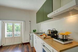 a kitchen with green cabinets and a counter top at Maroggia Apartments in Maroggia