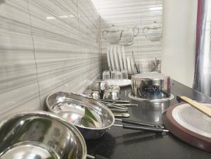a kitchen counter with bowls and utensils on it at Eesha Elite - Rameswaram in Rāmeswaram +17 photos