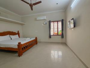a bedroom with a wooden bed and a window at Eesha Elite - Rameswaram in Rāmeswaram