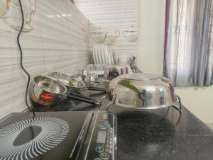 a kitchen counter with a stove with pots and pans at Eesha Elite - Rameswaram in Rāmeswaram