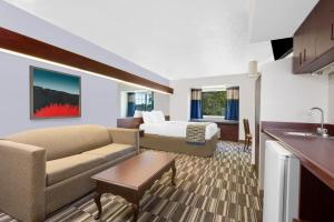 a hotel room with a bed and a living room at Microtel Inn & Suites by Wyndham London in London