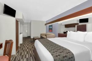 a large white bed in a hotel room at Microtel Inn & Suites by Wyndham London in London +165 photos
