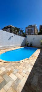 a small blue swimming pool next to a white wall at Moraes Residence in Belo Horizonte