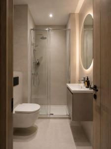 a bathroom with a shower and a toilet and a sink at Guest House LeGourmet in Kata Beach