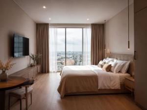 a bedroom with a large bed and a large window at Guest House LeGourmet in Kata Beach