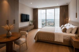 a bedroom with a bed and a table and a television at Guest House LeGourmet in Kata Beach