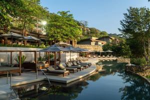 a pool with chairs and umbrellas in a resort at Andaz Peninsula Papagayo Resort, Costa Rica, by Hyatt in Culebra