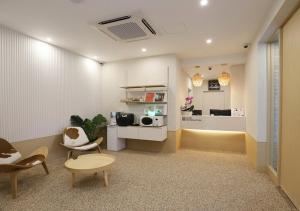 ein Wohnzimmer mit Stühlen, einem Tisch und einer Mikrowelle in der Unterkunft Chuncheon Pine Tree Hotel in Chuncheon