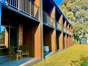 a building with chairs and a table on the side at Canberra Park Motel in Canberra