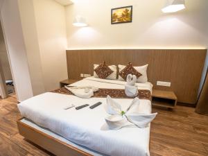 two beds in a hotel room with towels on them at GRAND ONE TOWER in Chennai