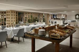 a restaurant with a table with white tables and chairs at Hyatt Regency Hesperia Madrid in Madrid
