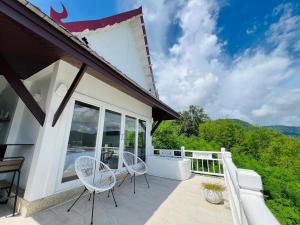 a patio with two chairs and a table on a balcony at Villa H in Surin Beach